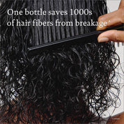 A close-up of a hand combing wet, curly hair with text overlay: Leave-In Conditioning Spray—your wash day essential—saves thousands of hair fibers from breakage.*.